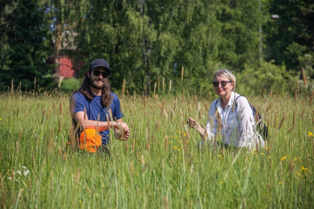 Ketosirkka-hankkeen Jaana Patrakka ja Matti Saarni kykkivät Pappilantien pörriäisniityllä aurinkoisena päivänä.