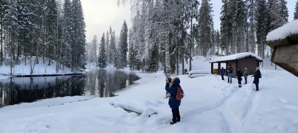 Luminen joen varsi, jossa ihmiset kiikaroimassa lintuja.