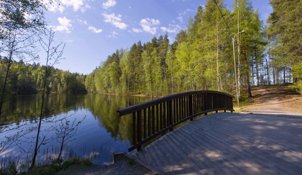 Kävelysilta kapean salmen yli, taustalla metsää. 