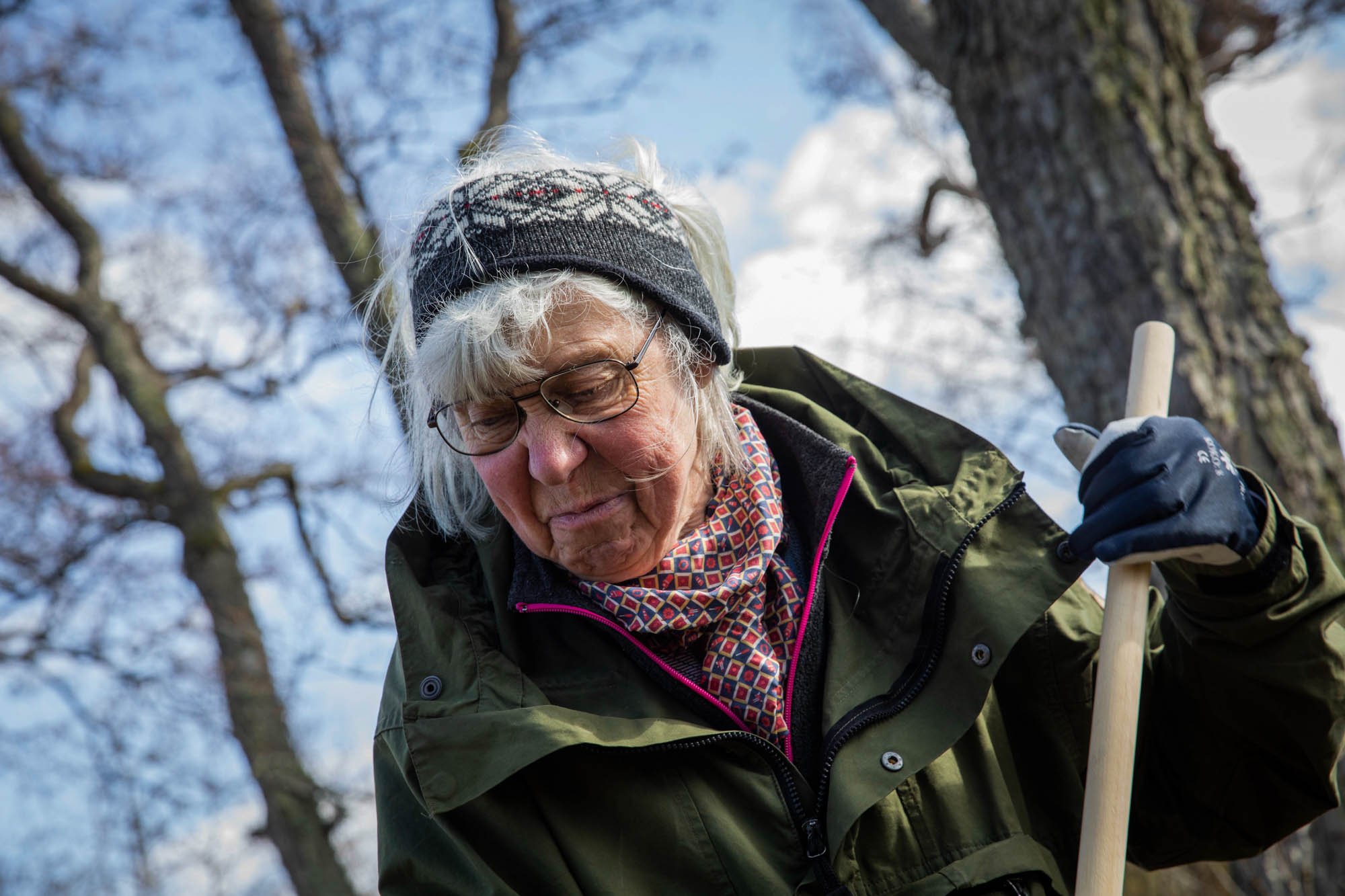 Kuvassa on lähikuva haravoivasta talkoolaisesta.